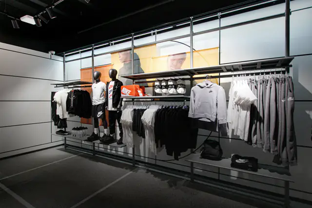Branded sportswear and overstock clothing on racks and mannequins in a store