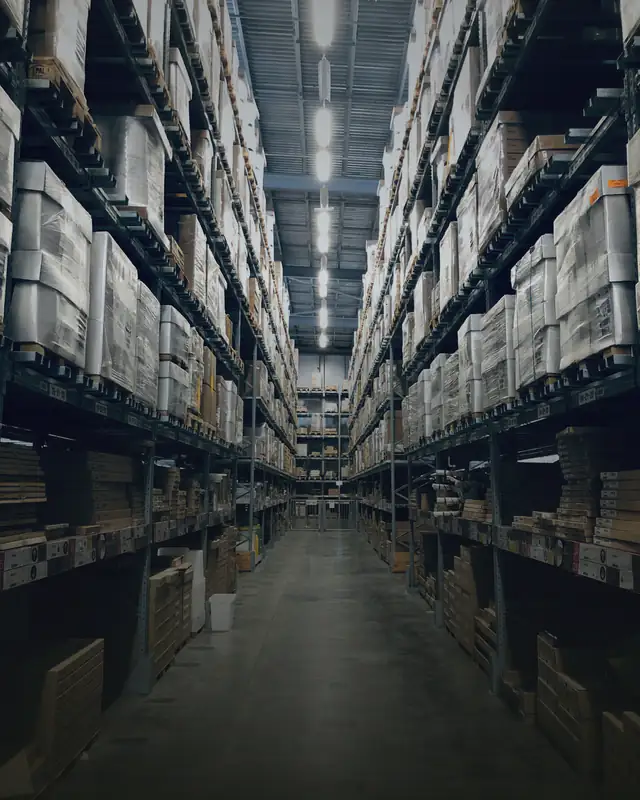 Long warehouse aisle with high racks of boxed stock